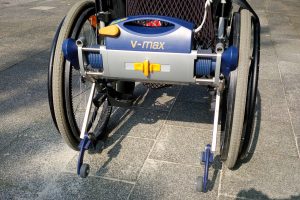 Ein normaler Schiebe-Rollstuhl lässt sich meistens zusammenfalten, so dass er für viele Alltags-Situationen geeignet ist. Aber: Eine zweite Person muss den Rollstuhl eben schieben, was ganz schön anstrengend sein kann. Ein Ausweg kann eine Rollstuhl-Schiebehilfe sein, die auch gleichzeitig beim Bremsen hilft. (Bildrechte: FRAGDENSTEIN.DE/ Stein)